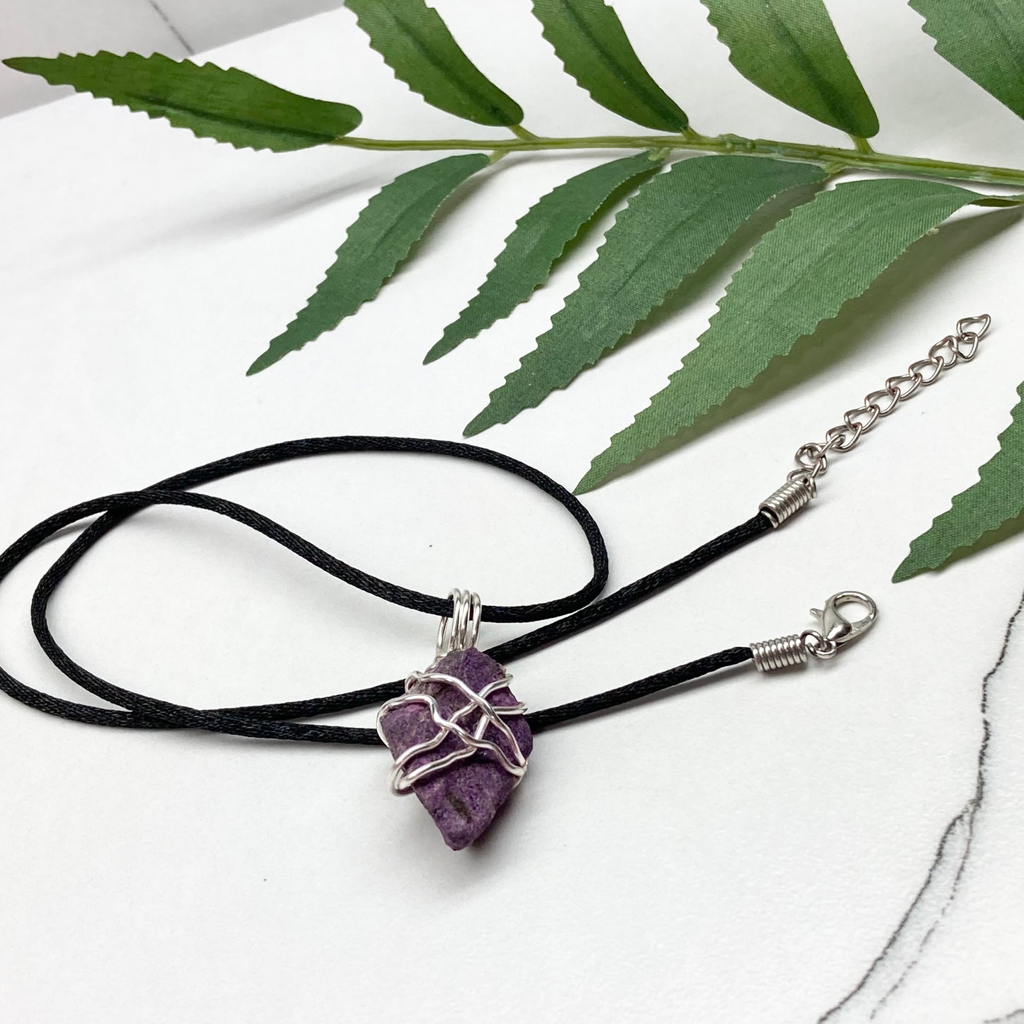 Purpurite necklace. Raw purple Purpurite stone wrapped with silver colored copper wire. Hangs on a black chain. Raw real crystal pendant.