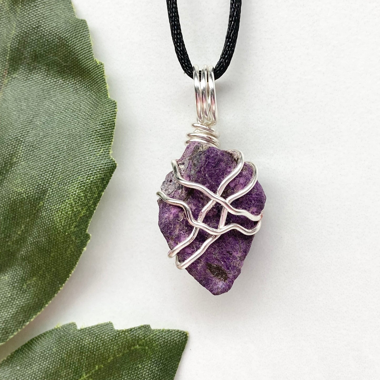 Purpurite necklace. Raw purple Purpurite stone wrapped with silver colored copper wire. Hangs on a black chain. Raw real crystal pendant.