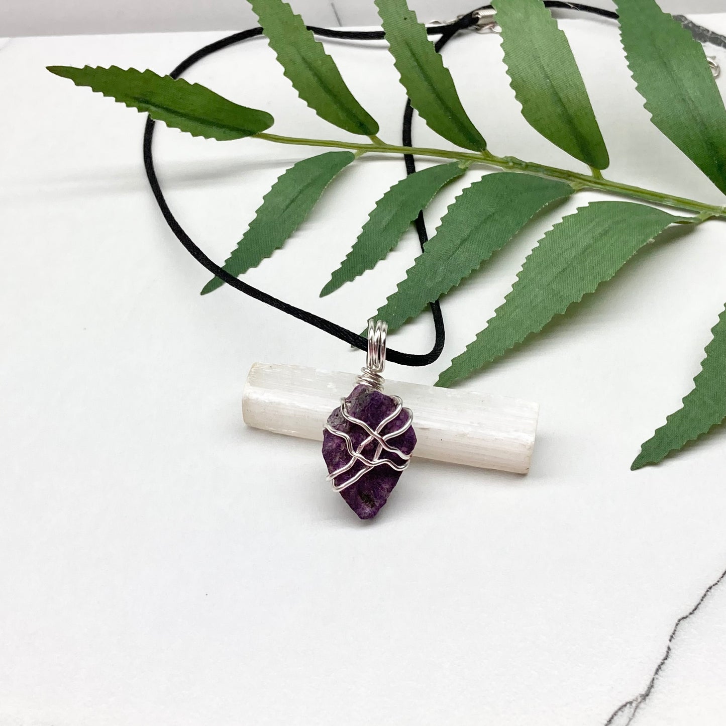 Purpurite necklace. Raw purple Purpurite stone wrapped with silver colored copper wire. Hangs on a black chain. Raw real crystal pendant.