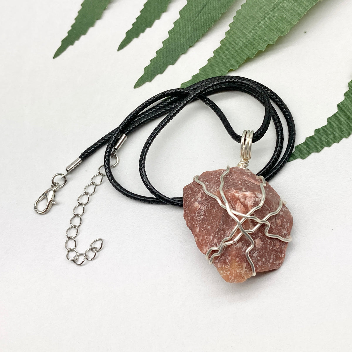 Red Aventurine necklace. Reddish brown stone wrapped with silver copper wire. Hangs on a black chain. Handcrafted spiritual jewelry.