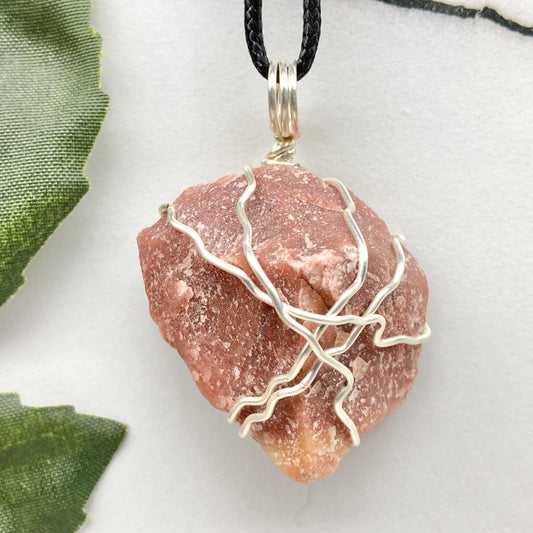 Red Aventurine necklace. Reddish brown stone wrapped with silver copper wire. Hangs on a black chain. Handcrafted spiritual jewelry.