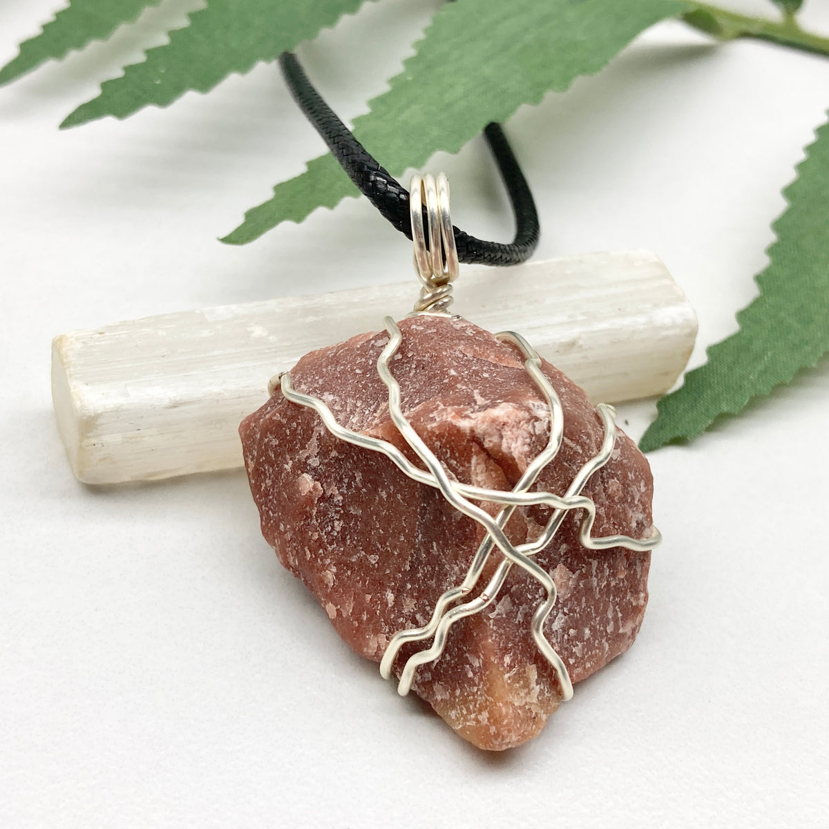 Red Aventurine necklace. Reddish brown stone wrapped with silver copper wire. Hangs on a black chain. Handcrafted spiritual jewelry.