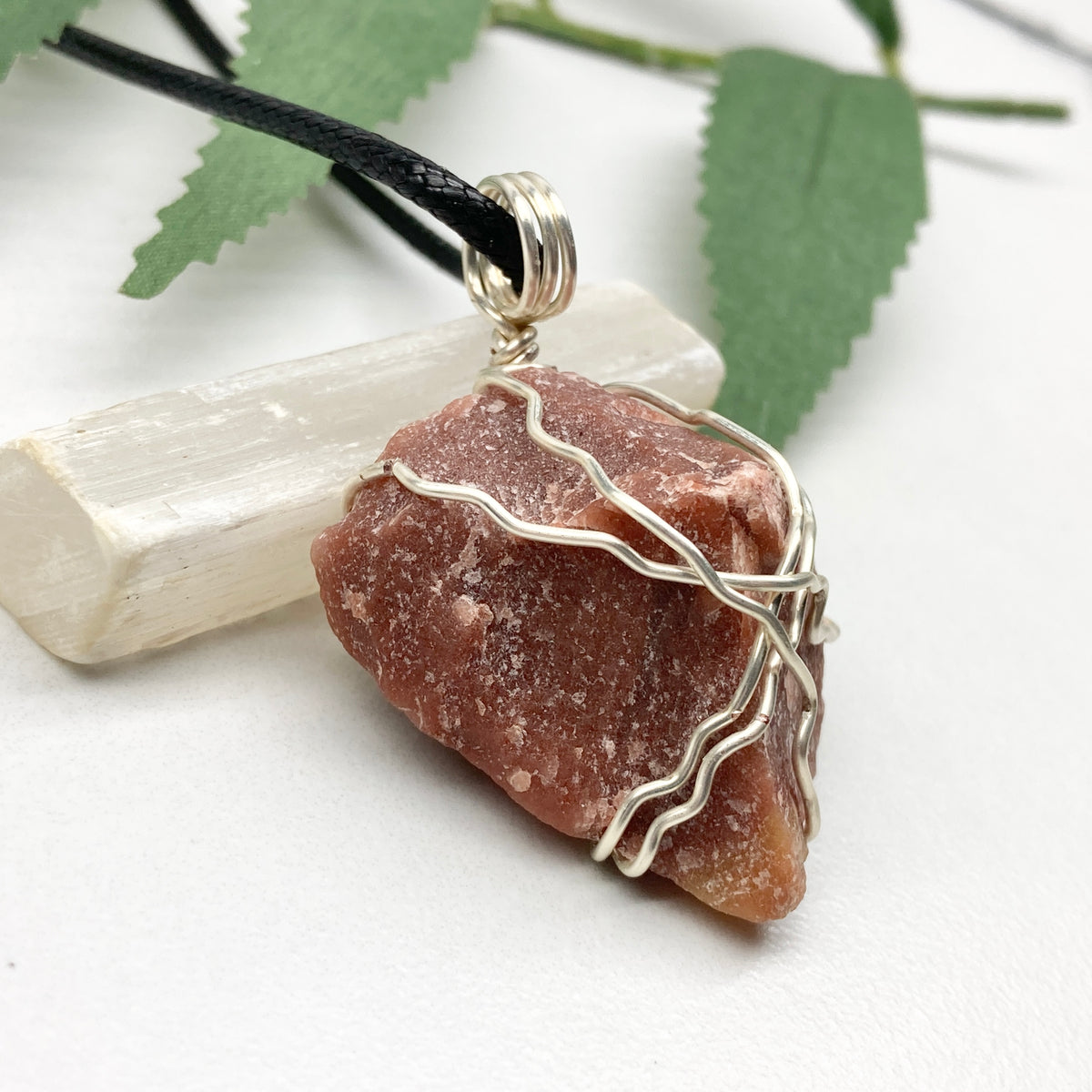 Red Aventurine necklace. Reddish brown stone wrapped with silver copper wire. Hangs on a black chain. Handcrafted spiritual jewelry.