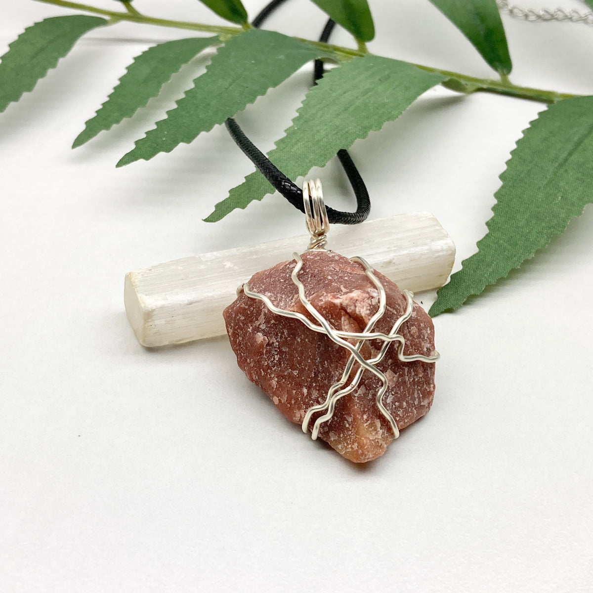 Red Aventurine necklace. Reddish brown stone wrapped with silver copper wire. Hangs on a black chain. Handcrafted spiritual jewelry.