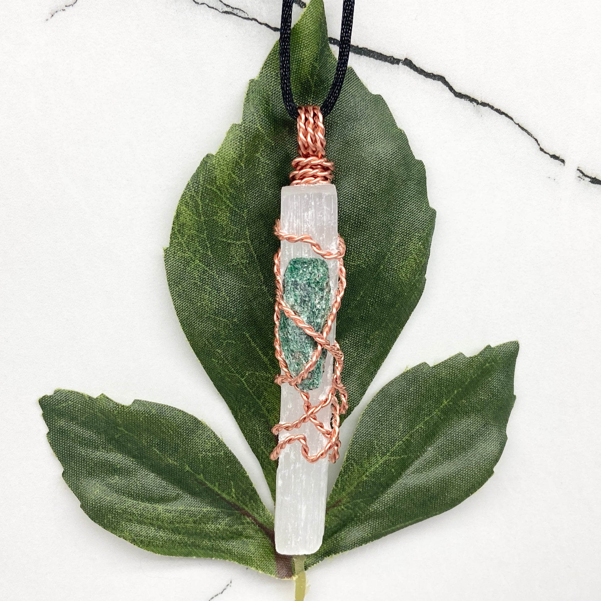 Selenite Fuchsite necklace. A Selenite stick and a raw Fuchsite wrapped together with copper wire. White and green double crystal pendant. Hangs on a black chain. 