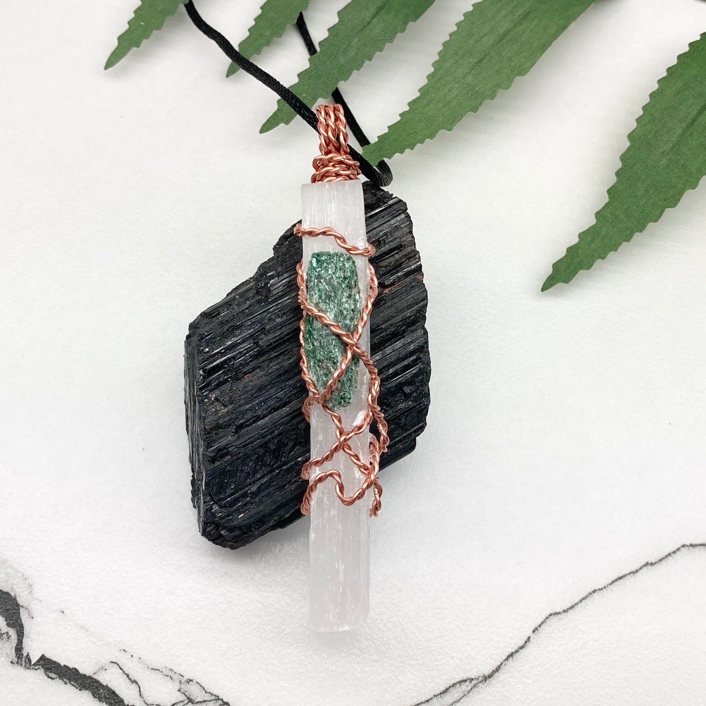 Selenite Fuchsite necklace. A Selenite stick and a raw Fuchsite wrapped together with copper wire. White and green double crystal pendant. Hangs on a black chain. 