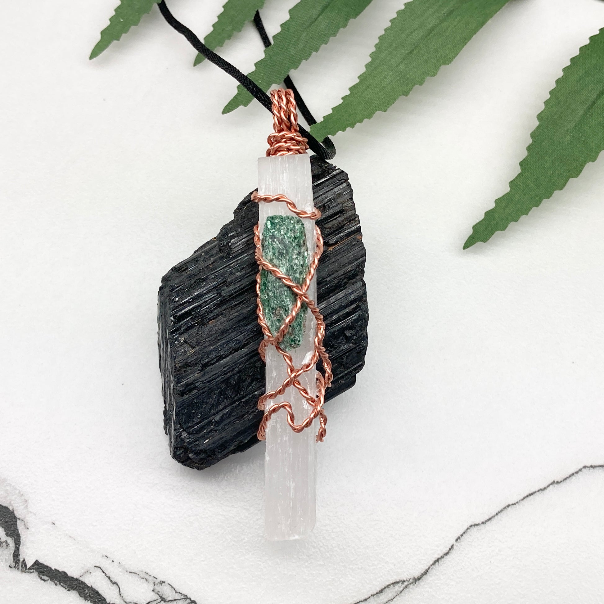 Selenite Fuchsite necklace. A Selenite stick and a raw Fuchsite wrapped together with copper wire. White and green double crystal pendant. Hangs on a black chain. 