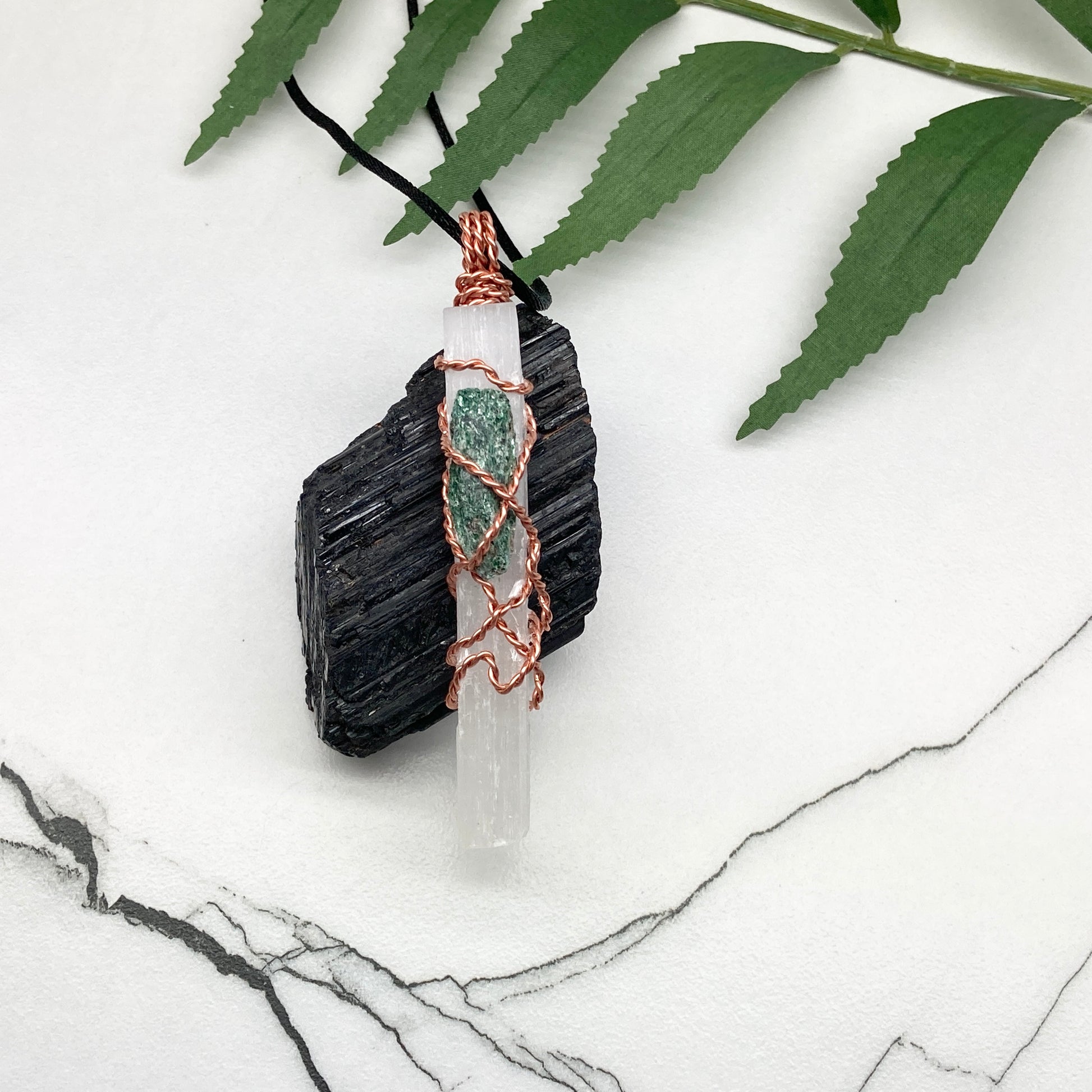 Selenite Fuchsite necklace. A Selenite stick and a raw Fuchsite wrapped together with copper wire. White and green double crystal pendant. Hangs on a black chain. 