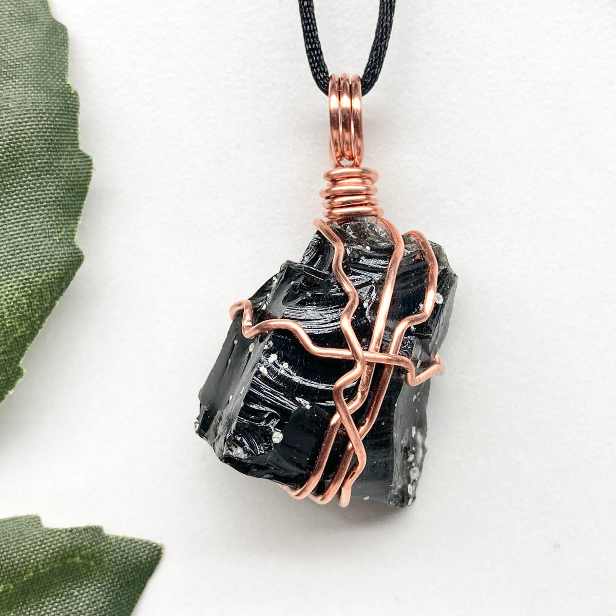 Snowflake Obsidian necklace. Black stone with gray spots wrapped with pure copper wire. Hangs on a black chain. Spiritual handmade jewelry.