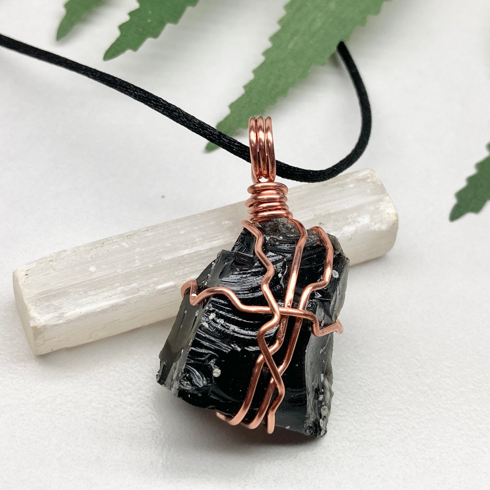 Snowflake Obsidian necklace. Black stone with gray spots wrapped with pure copper wire. Hangs on a black chain. Spiritual handmade jewelry.