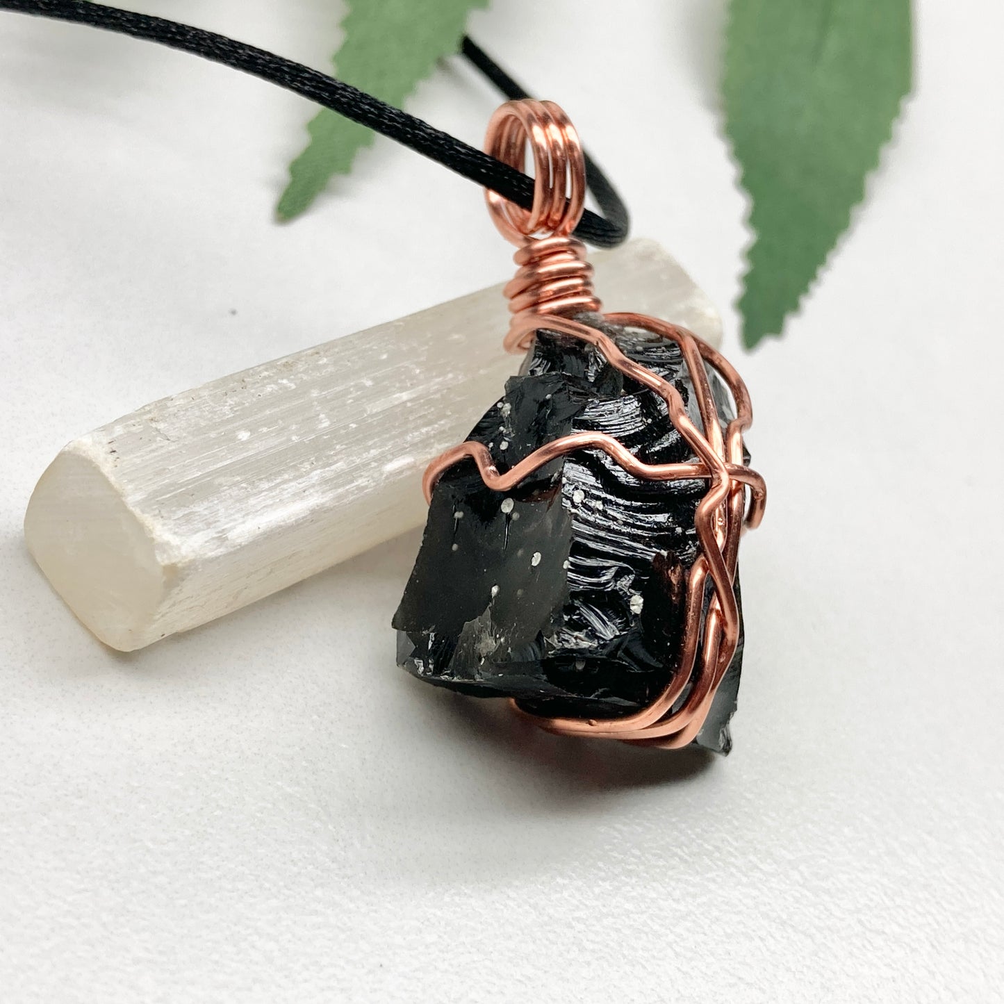 Snowflake Obsidian necklace. Black stone with gray spots wrapped with pure copper wire. Hangs on a black chain. Spiritual handmade jewelry.