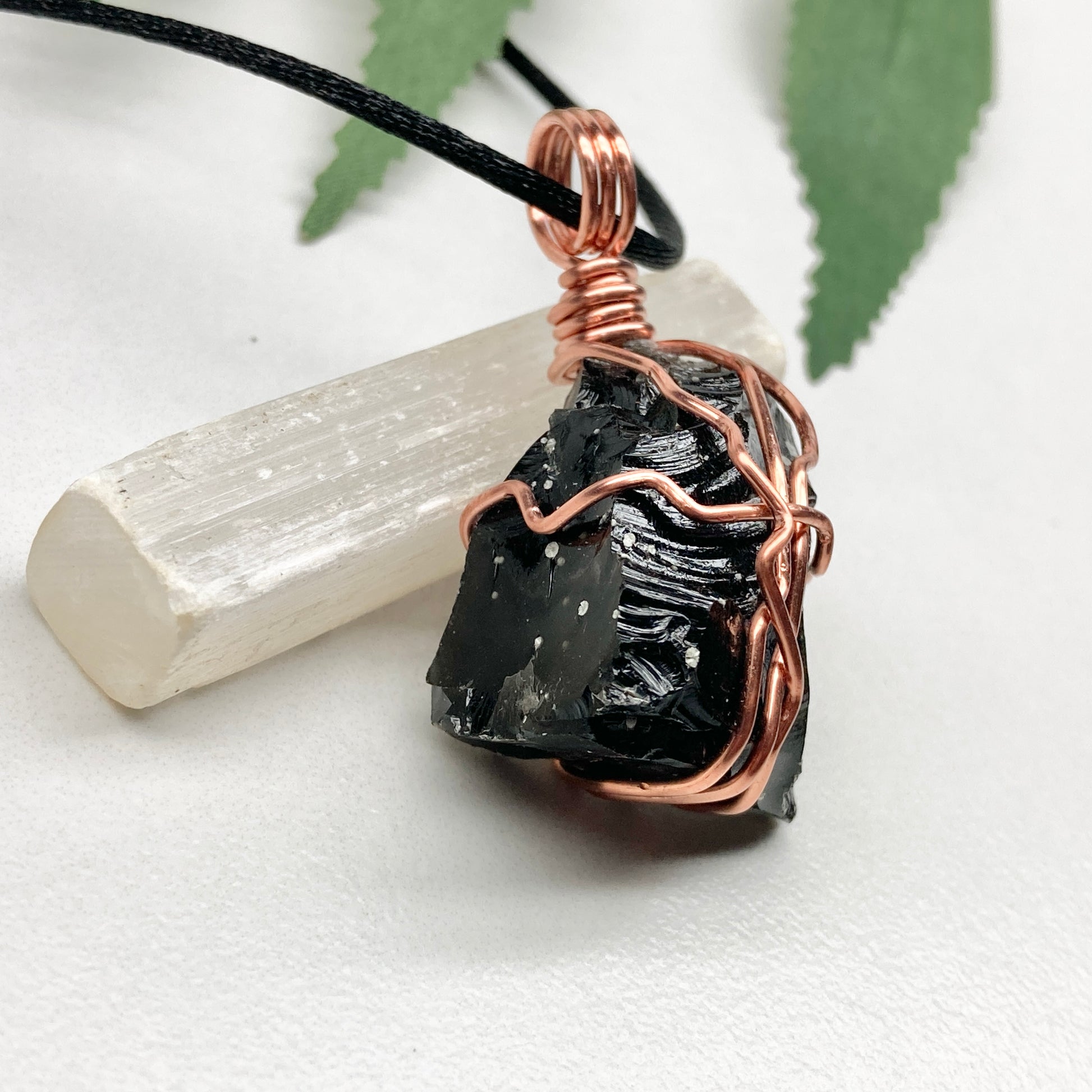 Snowflake Obsidian necklace. Black stone with gray spots wrapped with pure copper wire. Hangs on a black chain. Spiritual handmade jewelry.