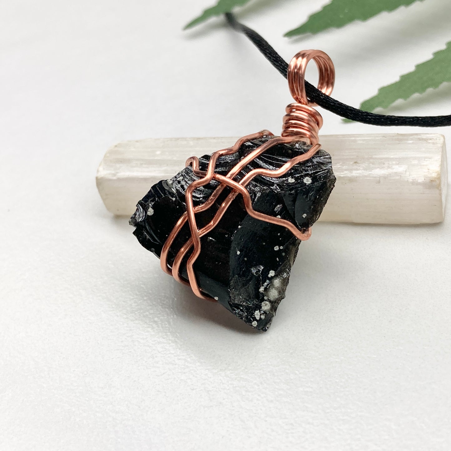 Snowflake Obsidian necklace. Black stone with gray spots wrapped with pure copper wire. Hangs on a black chain. Spiritual handmade jewelry.
