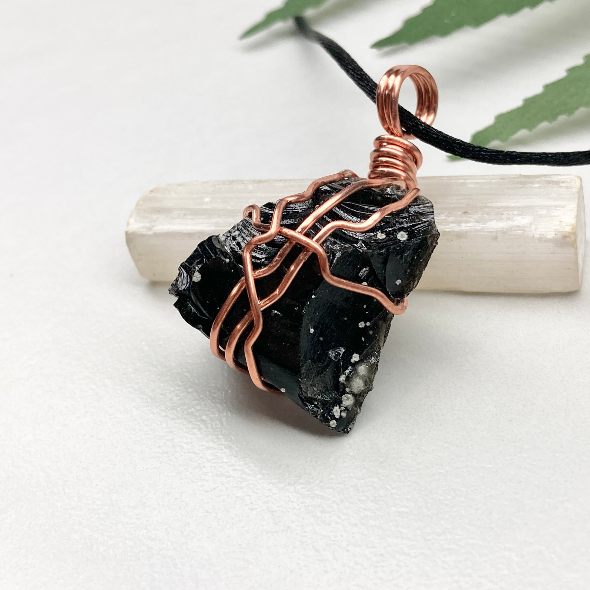 Snowflake Obsidian necklace. Black stone with gray spots wrapped with pure copper wire. Hangs on a black chain. Spiritual handmade jewelry.