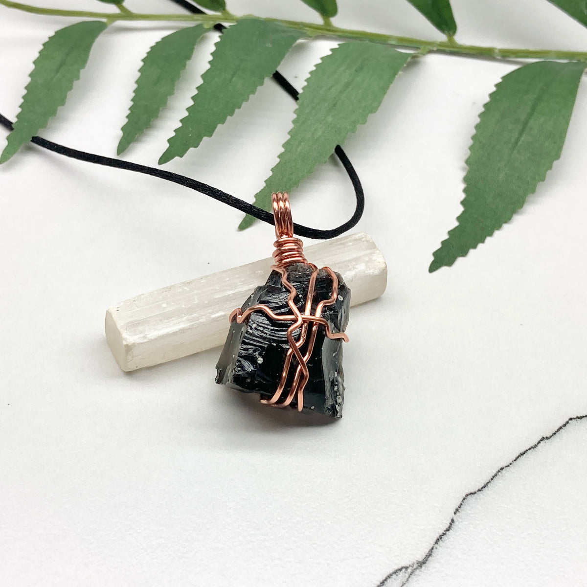 Snowflake Obsidian necklace. Black stone with gray spots wrapped with pure copper wire. Hangs on a black chain. Spiritual handmade jewelry.