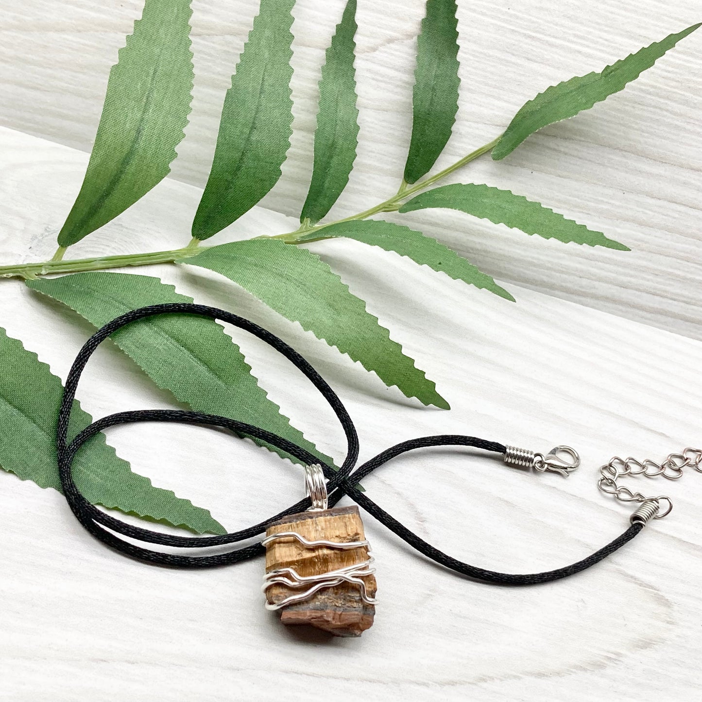 Tigers Eye necklace. Raw Tiger Eye stone wrapped with tarnish resistant silver copper wire. This stone is gold and brown. Unisex handmade pendant. Comes on a black chain with silver ends. Leo zodiac gift. 