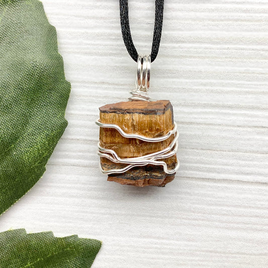Tigers Eye necklace. Raw Tiger Eye stone wrapped with tarnish resistant silver copper wire. This stone is gold and brown. Unisex handmade pendant. Comes on a black chain with silver ends. Leo zodiac gift. 