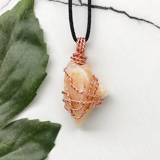 Yellow Opal necklace. Raw yellow stone wrapped with pure copper wire. Hangs on a black chain.