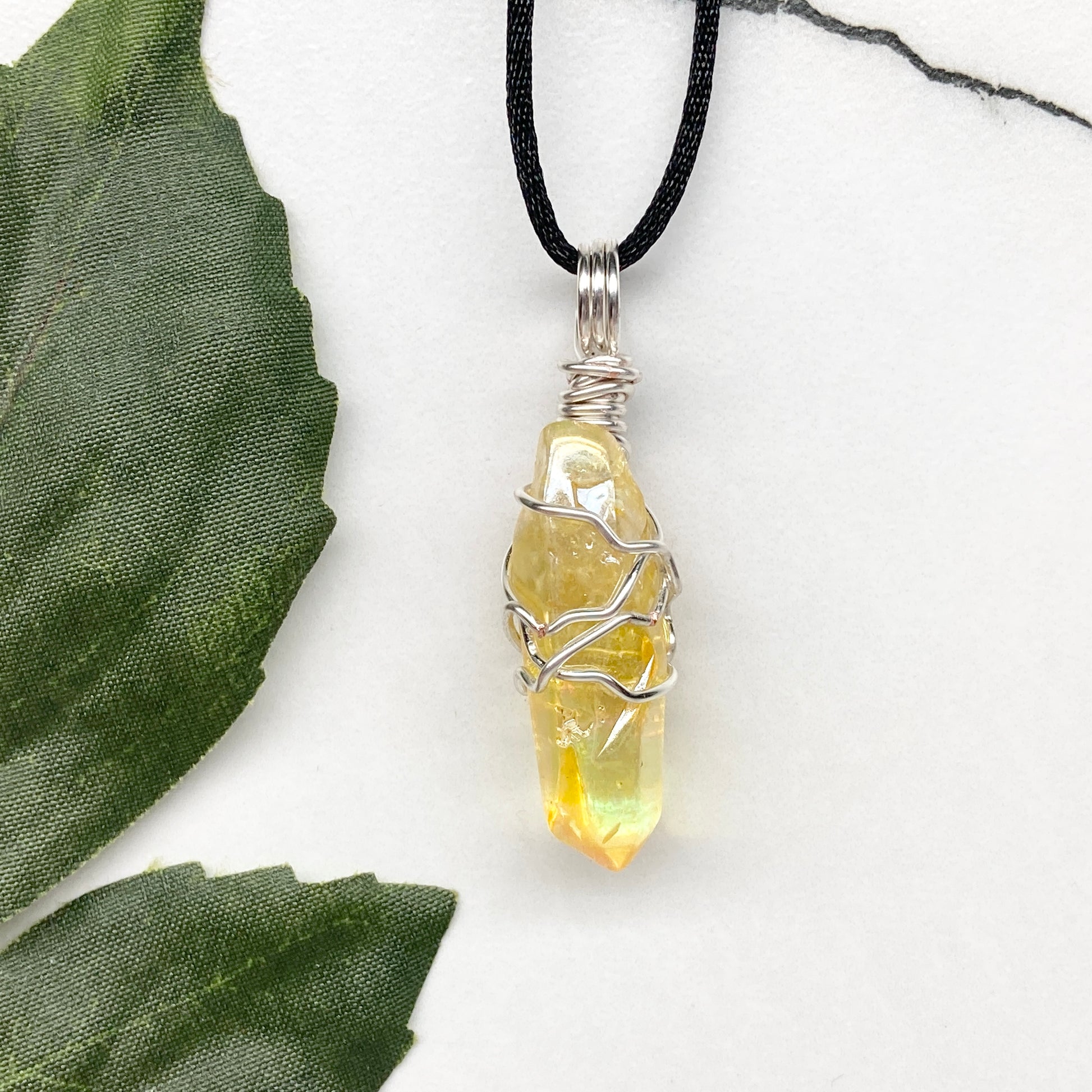 Yellow Aura Quartz necklace. Yellow crystal wrapped with silver colored copper wire. Hangs on a black chain. Handmade yellow stone pendant.