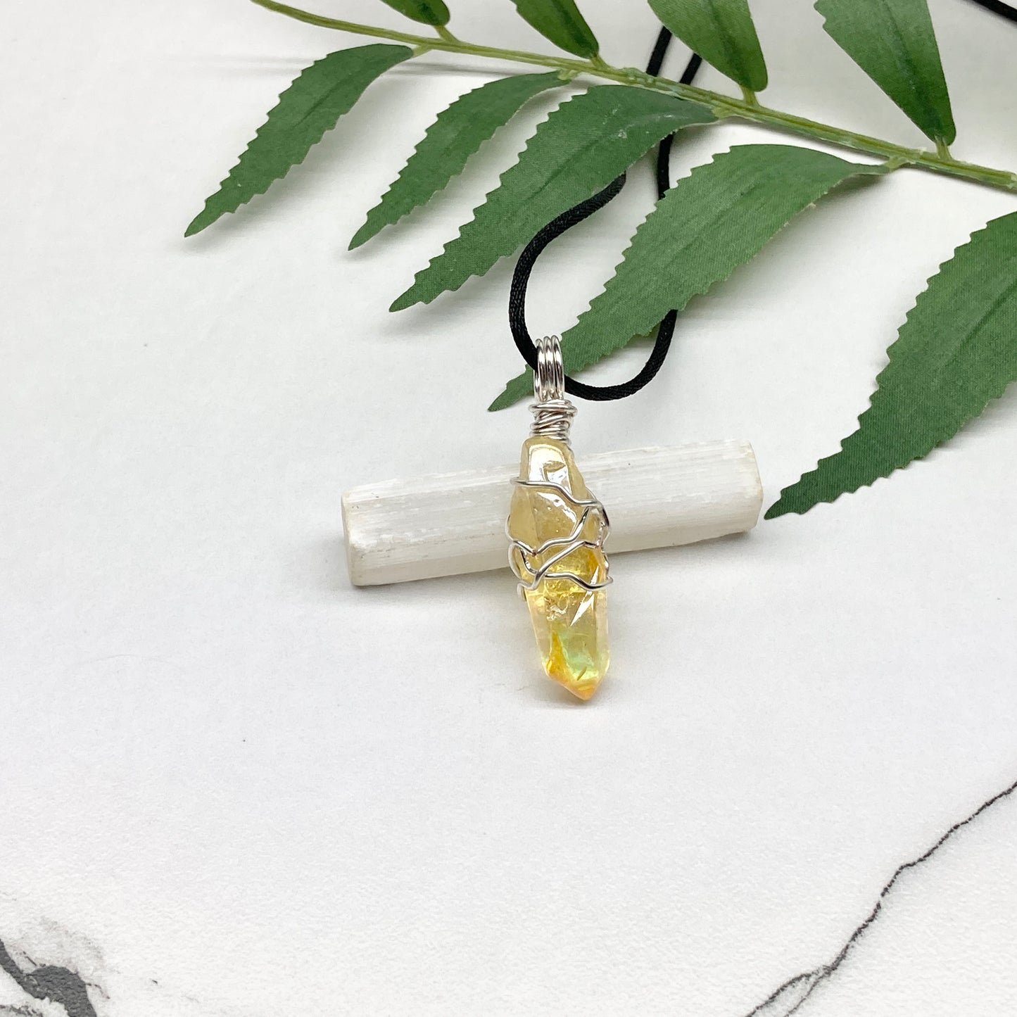 Yellow Aura Quartz necklace. Yellow crystal wrapped with silver colored copper wire. Hangs on a black chain. Handmade yellow stone pendant.