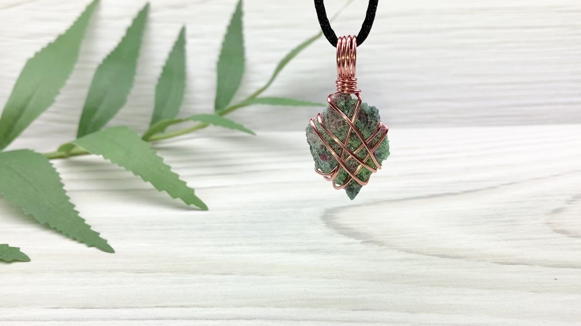 Raw Ruby Zoisite Necklace. This Ruby Zoisite Crystal Is Hand Wrapped With Pure Copper Wire For A Pendant. This Stone is Blue, Red And Green Colored. Comes On A Black Chain. Spiritual New Age Style Jewelry. Video Shows Pendant Spinning around.