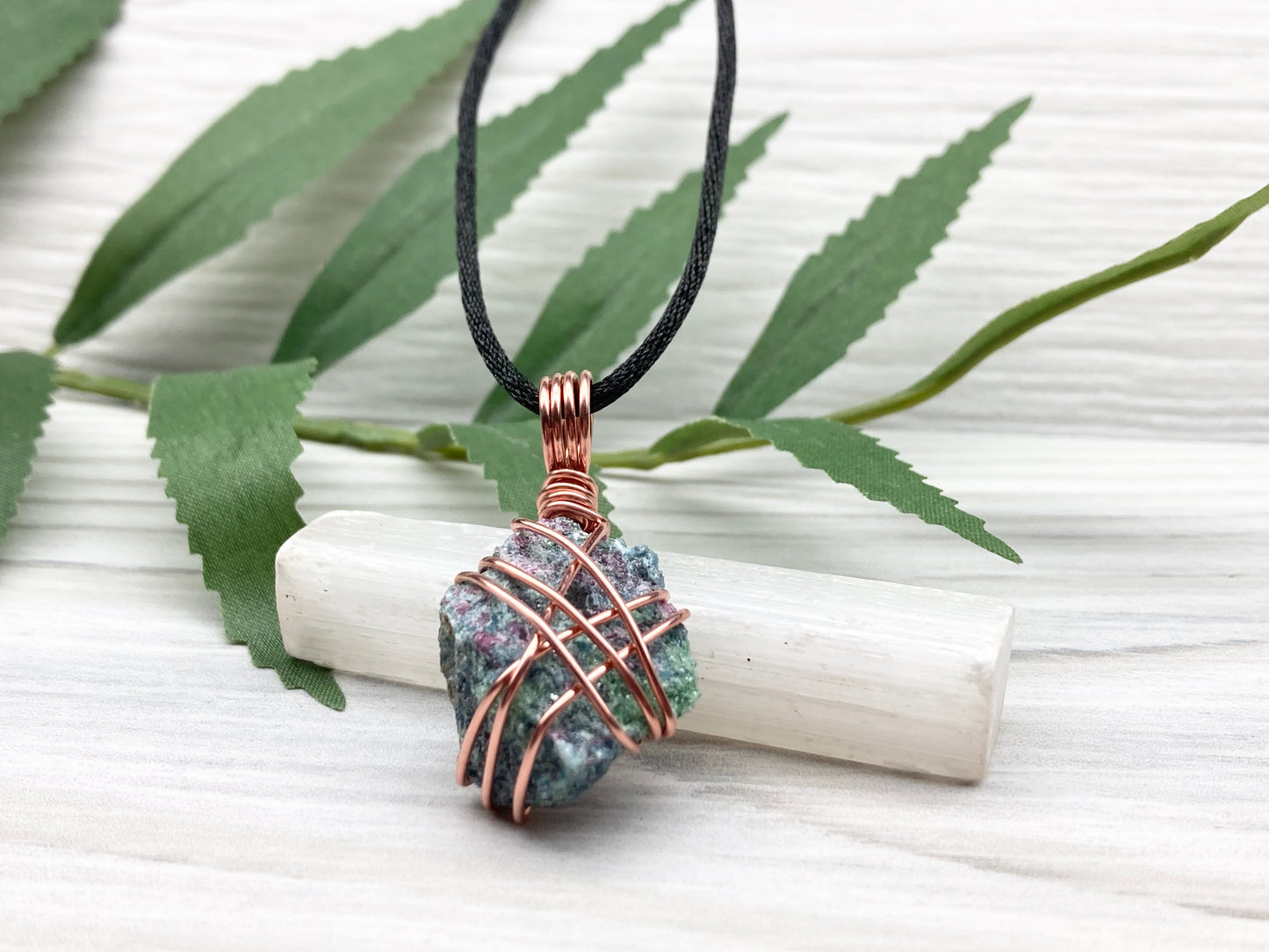 Raw Ruby Zoisite Necklace. This Ruby Zoisite Crystal Is Hand Wrapped With Pure Copper Wire For A Pendant. This Stone is Blue, Red And Green Colored. Comes On A Black Chain. Spiritual New Age Style Jewelry. Bottom View.