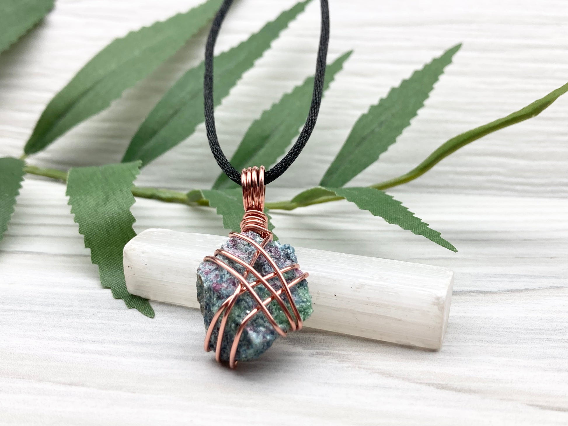 Raw Ruby Zoisite Necklace. This Ruby Zoisite Crystal Is Hand Wrapped With Pure Copper Wire For A Pendant. This Stone is Blue, Red And Green Colored. Comes On A Black Chain. Spiritual New Age Style Jewelry. Bottom View.