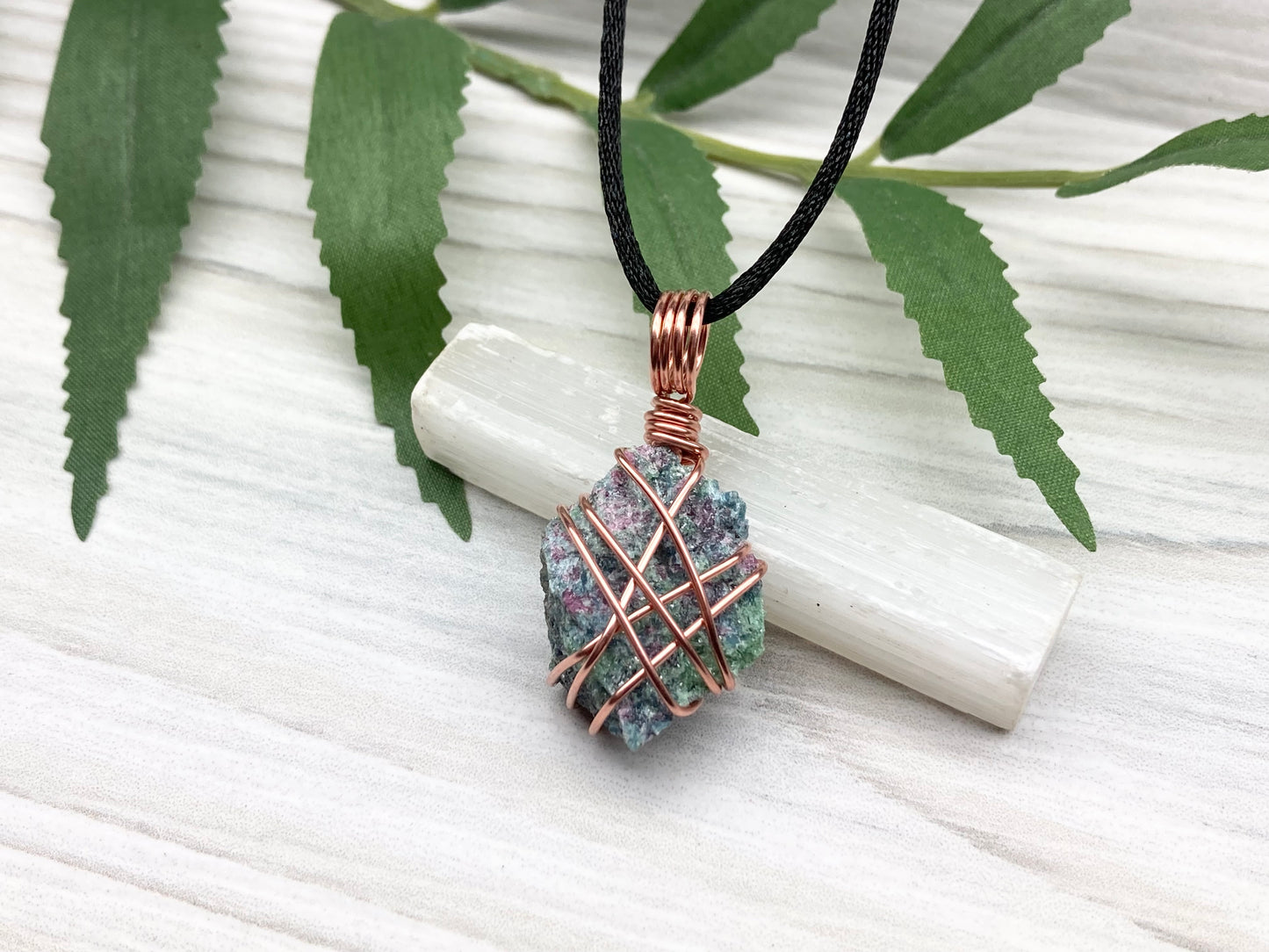 Raw Ruby Zoisite Necklace. This Ruby Zoisite Crystal Is Hand Wrapped With Pure Copper Wire For A Pendant. This Stone is Blue, Red And Green Colored. Comes On A Black Chain. Spiritual New Age Style Jewelry.