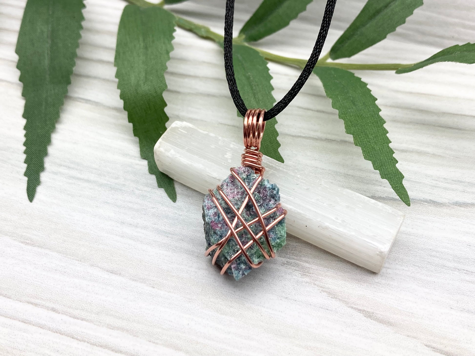 Raw Ruby Zoisite Necklace. This Ruby Zoisite Crystal Is Hand Wrapped With Pure Copper Wire For A Pendant. This Stone is Blue, Red And Green Colored. Comes On A Black Chain. Spiritual New Age Style Jewelry.