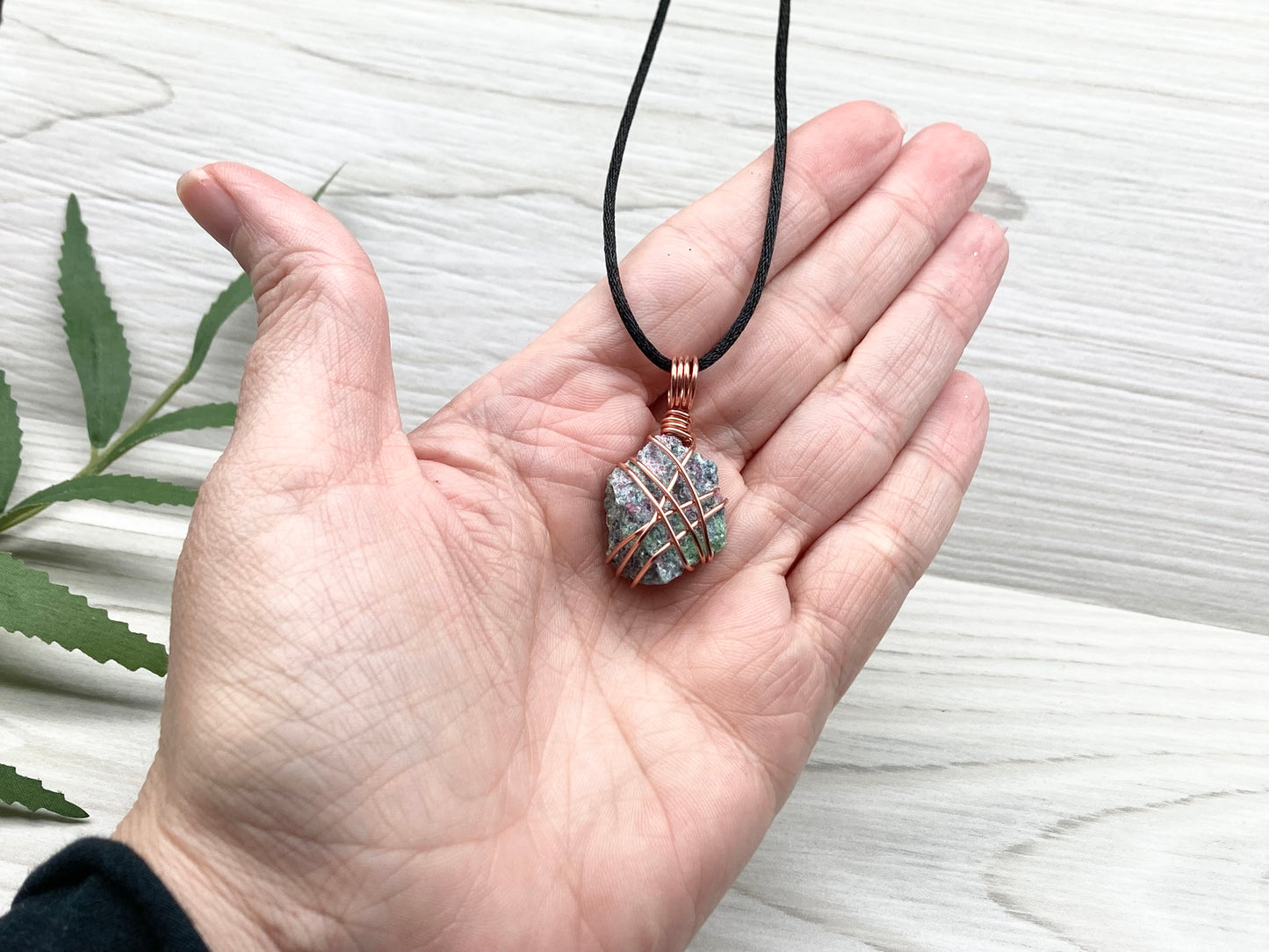 Raw Ruby Zoisite Necklace. This Ruby Zoisite Crystal Is Hand Wrapped With Pure Copper Wire For A Pendant. This Stone is Blue, Red And Green Colored. Comes On A Black Chain. Spiritual New Age Style Jewelry.