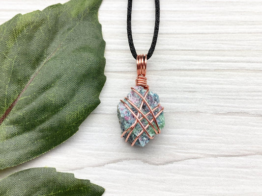 Raw Ruby Zoisite Necklace. This Ruby Zoisite Crystal Is Hand Wrapped With Pure Copper Wire For A Pendant. This Stone is Blue, Red And Green Colored. Comes On A Black Chain. Spiritual New Age Style Jewelry.