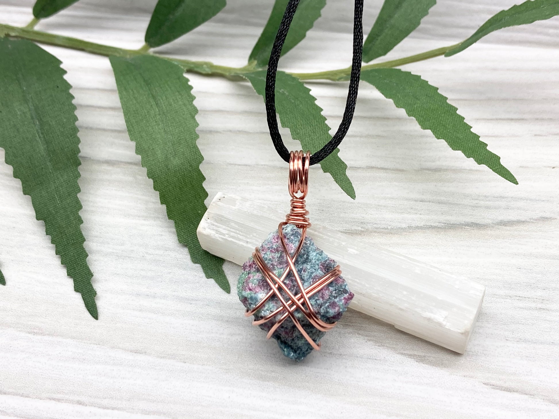 Rough Raw Ruby Zoisite Necklace. This Ruby Zoisite Crystal Is Hand Wrapped With Pure Copper Wire. This Stone is Blue and Red Colored. Gemstone Comes On A Black Chain. Spiritual New Age Style Unisex Jewelry.